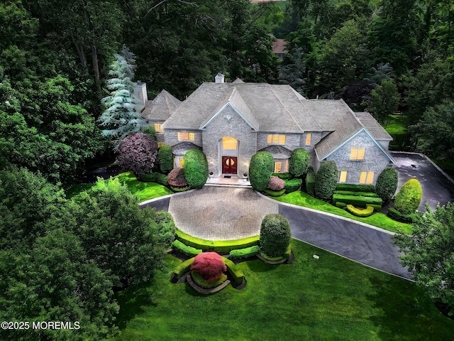 2 Red Oak, Holmdel, NJ 07733 - french provincial home featuring stone siding, a chimney, a front yard, and curved driveway