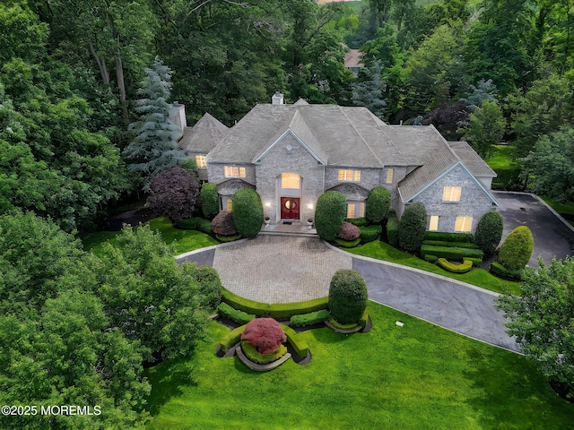 2 Red Oak, Holmdel, NJ 07733 - view of front of home featuring stone siding, a chimney, a front lawn, and curved driveway
