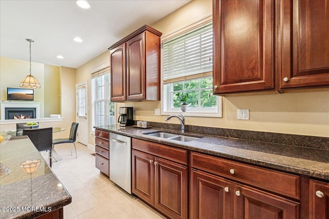 24 Rutledge Rd, Marlboro, NJ 07746 - kitchen with dishwasher, a glass covered fireplace, decorative light fixtures, dark stone countertops, and light tile patterned floors