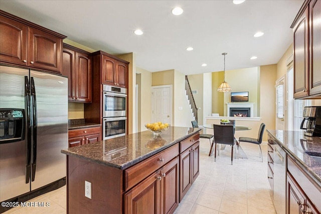 24 Rutledge Rd, Marlboro, NJ 07746 - kitchen with stainless steel appliances, light tile patterned flooring, a warm lit fireplace, recessed lighting, and dark stone countertops