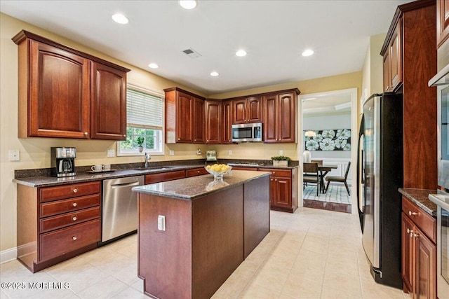 24 Rutledge Rd, Marlboro, NJ 07746 - kitchen with stainless steel appliances, recessed lighting, light tile patterned floors, a kitchen island, and dark stone countertops