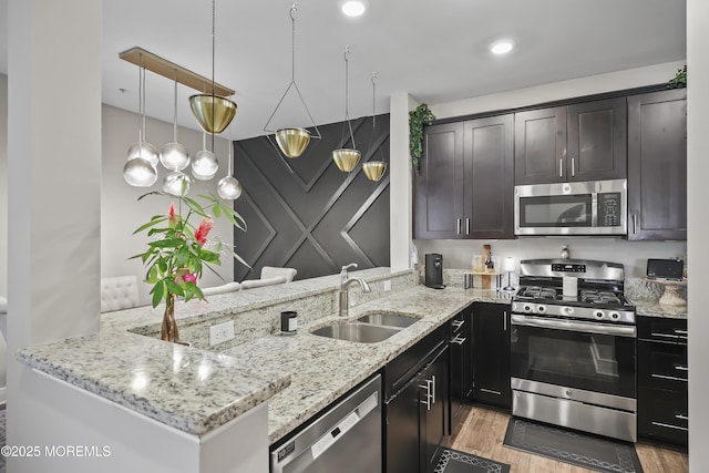 518 Tavern Rd, Monroe, NJ 08831 - kitchen with stainless steel appliances, light wood-style floors, light stone counters, dark brown cabinetry, and a peninsula