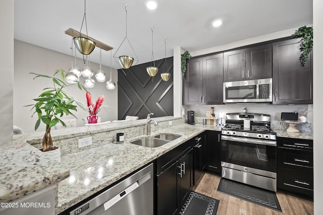 518 Tavern Rd, Monroe, NJ 08831 - kitchen featuring appliances with stainless steel finishes, light stone counters, light wood finished floors, hanging light fixtures, and recessed lighting