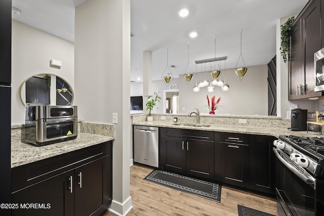 518 Tavern Rd, Monroe, NJ 08831 - kitchen featuring stainless steel appliances, light wood finished floors, light stone countertops, and a peninsula