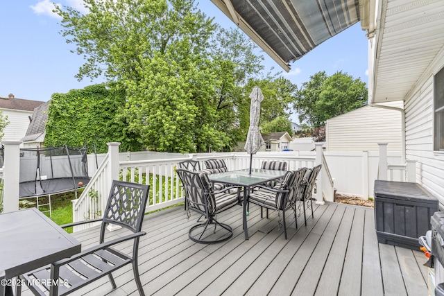 81 Lockwood Ave, Woodbridge, NJ 07095 - wooden deck featuring a trampoline, outdoor dining area, and a fenced backyard