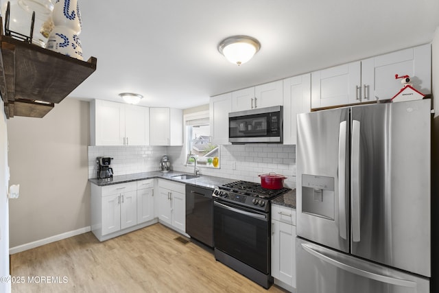 81 Lockwood Ave, Woodbridge, NJ 07095 - kitchen with stainless steel appliances, white cabinets, light wood-type flooring, tasteful backsplash, and dark stone countertops