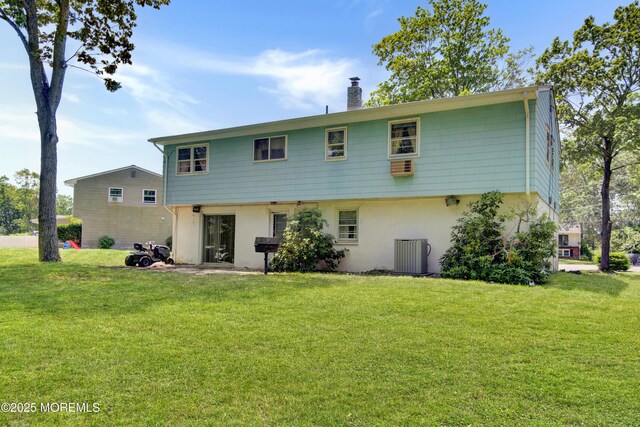 16 Burdge Dr, Howell, NJ 07731 - rear view of house with a chimney, stucco siding, and a lawn