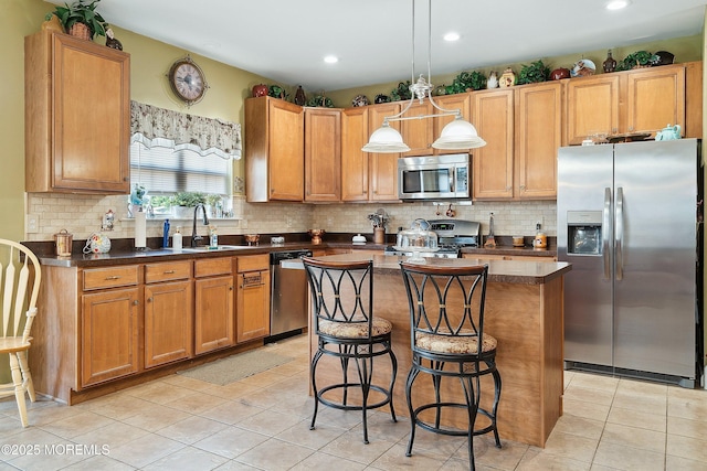 15 Savannah Dr, Barnegat, NJ 08005 - kitchen with stainless steel appliances, light tile patterned flooring, dark countertops, a kitchen breakfast bar, and a kitchen island