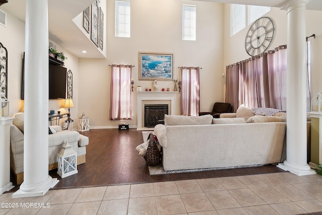 15 Savannah Dr, Barnegat, NJ 08005 - living area featuring ornate columns, a high ceiling, a glass covered fireplace, and tile patterned flooring