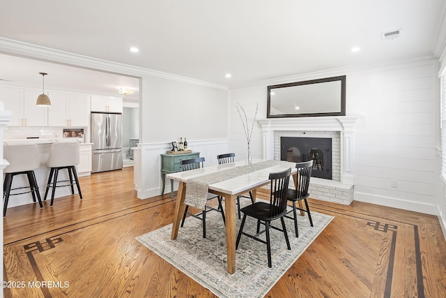 1810 Shore Blvd, Point Pleasant, NJ 08742 - dining room with a brick fireplace, ornamental molding, a decorative wall, light wood-type flooring, and recessed lighting