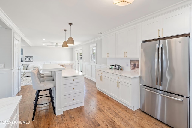 1810 Shore Blvd, Point Pleasant, NJ 08742 - kitchen featuring freestanding refrigerator, white cabinets, a kitchen bar, light wood-style flooring, and ornamental molding