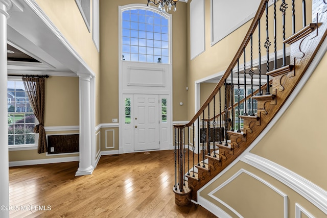 1 Ethan Dr, Farmingdale, NJ 07727 - entryway with a towering ceiling, ornate columns, wood-type flooring, stairway, and a chandelier