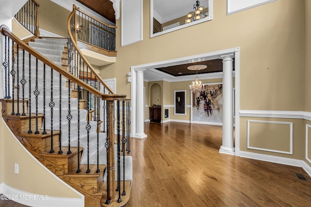 1 Ethan Dr, Farmingdale, NJ 07727 - foyer featuring ornate columns, a chandelier, ornamental molding, wood finished floors, and stairway