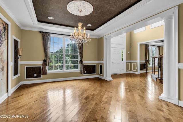 1 Ethan Dr, Farmingdale, NJ 07727 - unfurnished living room featuring a raised ceiling, ornate columns, a chandelier, healthy amount of natural light, and crown molding