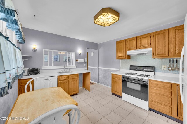 353 Cokes Dr, Toms River, NJ 08753 - kitchen featuring white gas stove, under cabinet range hood, light countertops, light tile patterned flooring, and a peninsula