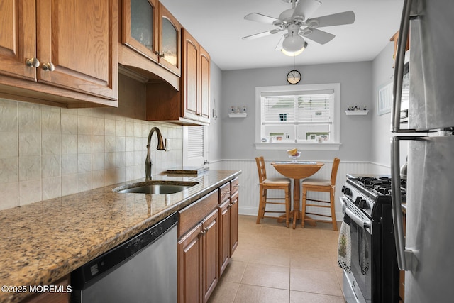10 Ann Ct, Tinton Falls, NJ 07724 - kitchen featuring appliances with stainless steel finishes, ceiling fan, stone counters, wainscoting, and glass insert cabinets