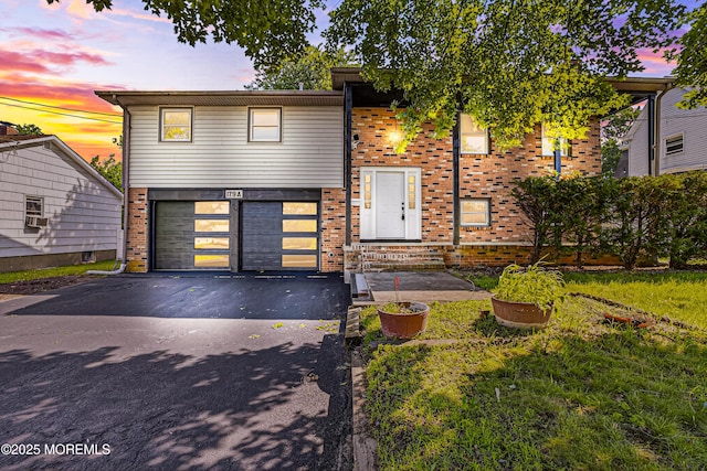 179A Buckelew Ave Unit A, Jamesburg, NJ 08831 - view of front facade featuring asphalt driveway, brick siding, and a garage
