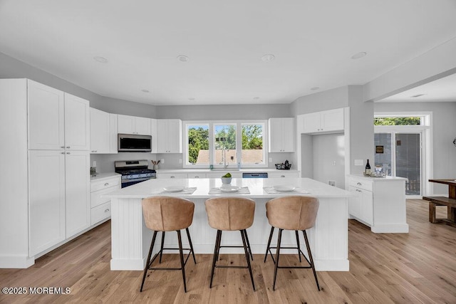 45 Shore Acres Ave, North Middletown, NJ 07748 - kitchen featuring appliances with stainless steel finishes, a kitchen island, light countertops, and white cabinetry