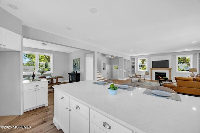 45 Shore Acres Ave, North Middletown, NJ 07748 - kitchen with a lit fireplace, light wood-style flooring, light stone counters, plenty of natural light, and recessed lighting