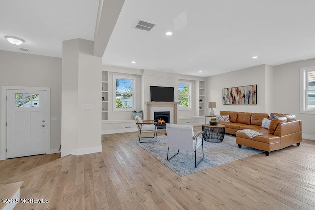 45 Shore Acres Ave, North Middletown, NJ 07748 - living area featuring built in shelves, light wood-style floors, a lit fireplace, healthy amount of natural light, and recessed lighting