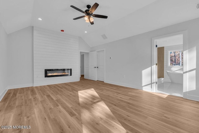 12 Outsail Ave, Barnegat, NJ 08005 - unfurnished living room featuring lofted ceiling, heating unit, ceiling fan, a large fireplace, and light wood-style flooring