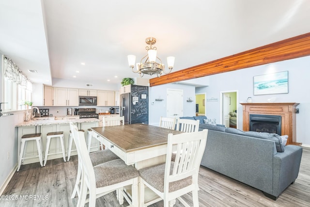 887 Beach Haven W Blvd, Manahawkin, NJ 08050 - dining area featuring a chandelier, light wood-type flooring, a glass covered fireplace, and recessed lighting