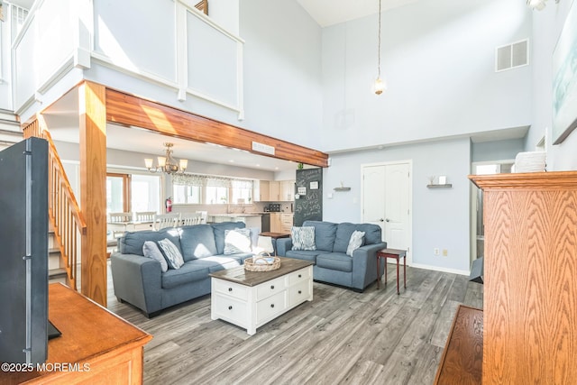 887 Beach Haven W Blvd, Manahawkin, NJ 08050 - living room with a towering ceiling, stairs, wood finished floors, and a chandelier