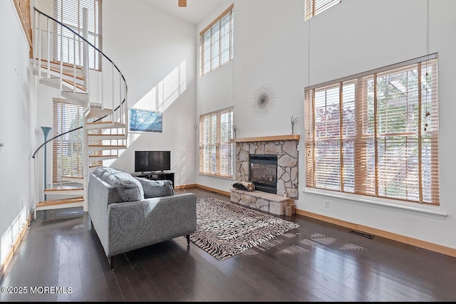 408 Brookdale Ave, Long Branch, NJ 07740 - living room featuring stairs, wood-type flooring, a towering ceiling, and a stone fireplace