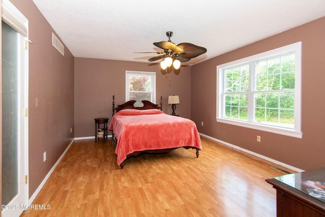 67 School Rd E, Marlboro, NJ 07746 - bedroom with multiple windows, light wood-type flooring, a ceiling fan, and a textured ceiling