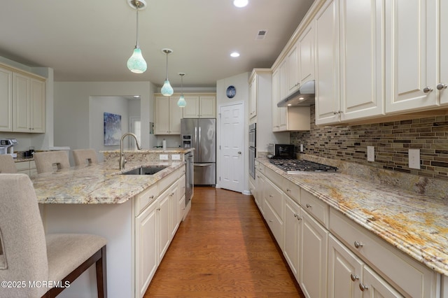 5 Gainsborough Ln, Manchester, NJ 08759 - kitchen featuring stainless steel appliances, wood finished floors, tasteful backsplash, a breakfast bar, and hanging light fixtures