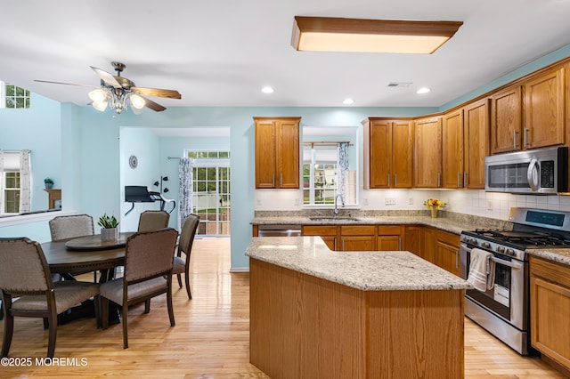 3 Knightsbridge Pl, Jackson, NJ 08527 - kitchen featuring stainless steel appliances, light wood-type flooring, a center island, tasteful backsplash, and brown cabinetry