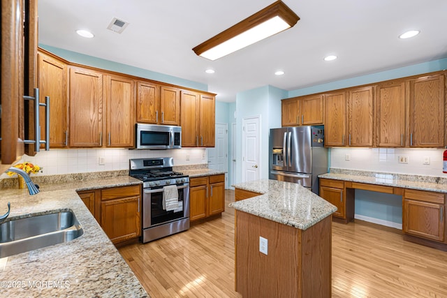 3 Knightsbridge Pl, Jackson, NJ 08527 - kitchen featuring stainless steel appliances, a center island, backsplash, built in desk, and light wood-style flooring