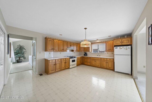 28 S Dayton Dr, Little Egg Harbor, NJ 08087 - kitchen with white appliances, light countertops, brown cabinetry, under cabinet range hood, and pendant lighting