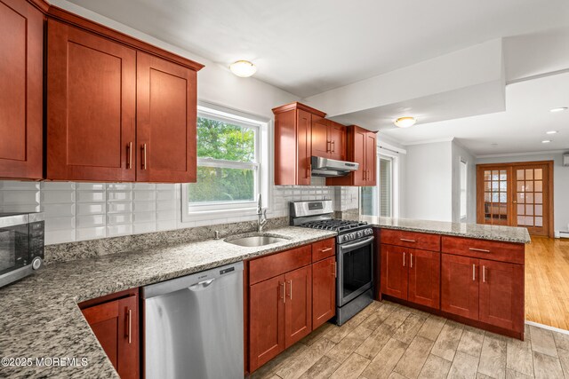 334 Norgrove Pl, Elberon, NJ 07740 - kitchen with appliances with stainless steel finishes, under cabinet range hood, a peninsula, light wood-style floors, and light stone counters