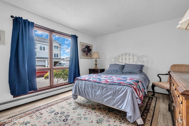 259 Cypress Dr, Bayville, NJ 08721 - bedroom with baseboard heating, wood finished floors, and a textured ceiling
