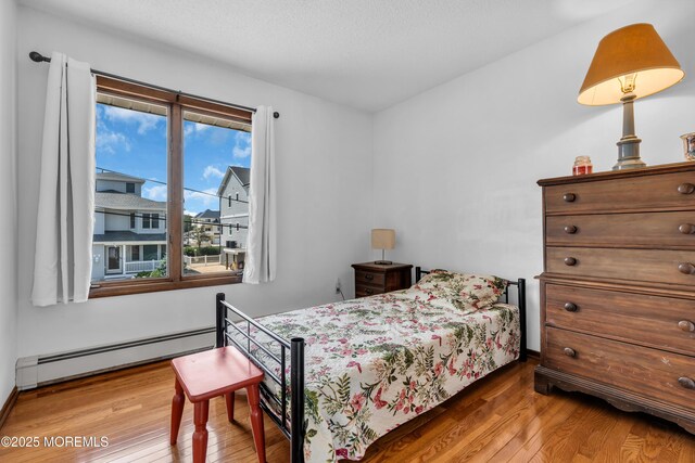 259 Cypress Dr, Bayville, NJ 08721 - bedroom with a baseboard radiator, wood-type flooring, and multiple windows