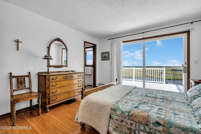 259 Cypress Dr, Bayville, NJ 08721 - bedroom with access to exterior, light wood-style floors, a textured ceiling, and a water view