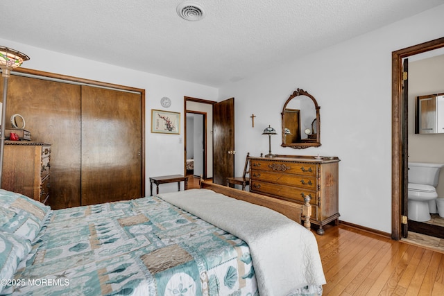259 Cypress Dr, Bayville, NJ 08721 - bedroom featuring light wood-style floors, a closet, a textured ceiling, and ensuite bathroom