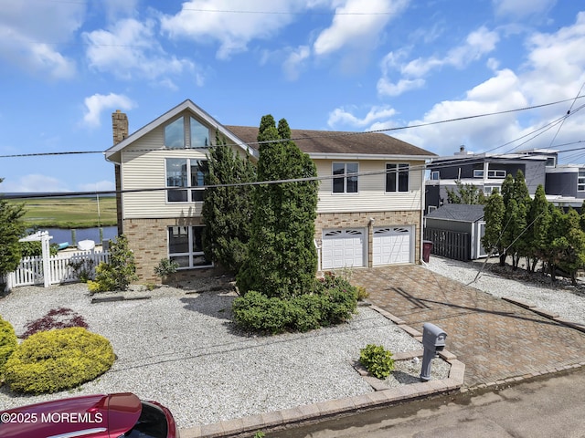 259 Cypress Dr, Bayville, NJ 08721 - view of front of house with brick siding, driveway, a garage, a water view, and a chimney