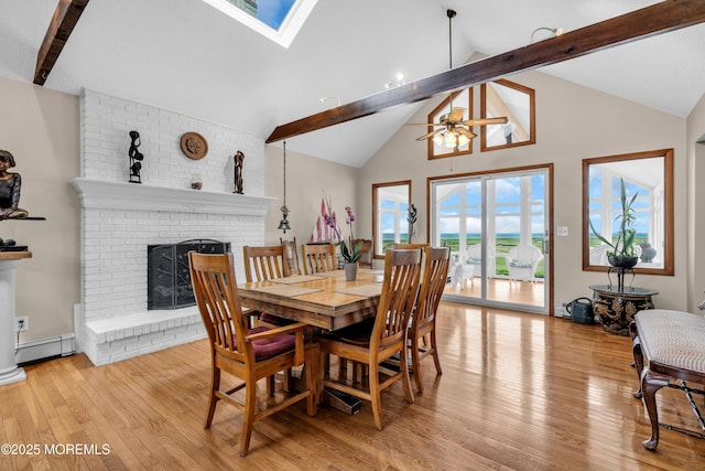 259 Cypress Dr, Bayville, NJ 08721 - dining area featuring beamed ceiling, a brick fireplace, a baseboard heating unit, light wood-type flooring, and ceiling fan