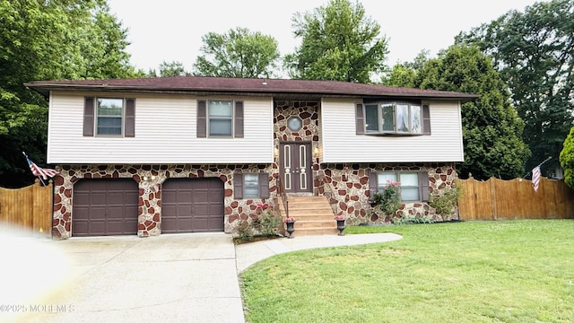 9 Longfellow Ter, Morganville, NJ 07751 - split foyer home featuring stone siding, an attached garage, and concrete driveway