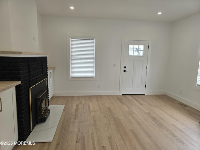 412 Ridge Ave, Neptune Township, NJ 07753 - unfurnished living room with light wood-style floors, a wood stove, and recessed lighting