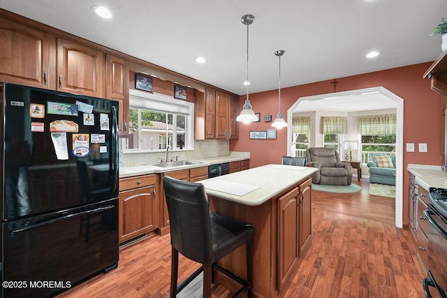 14 Village Rd, Morganville, NJ 07751 - kitchen featuring black appliances, a center island, light countertops, decorative backsplash, and brown cabinets
