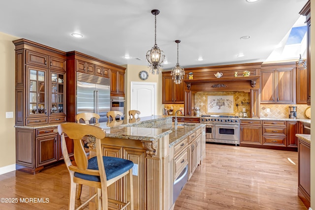 4 Geraldine Ct, Farmingdale, NJ 07727 - kitchen with high end appliances, a kitchen breakfast bar, light wood-style flooring, tasteful backsplash, and light stone countertops