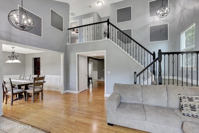 8 Shadow Ridge Ct, Howell, NJ 07731 - living room featuring a chandelier, light wood-type flooring, a high ceiling, and stairway