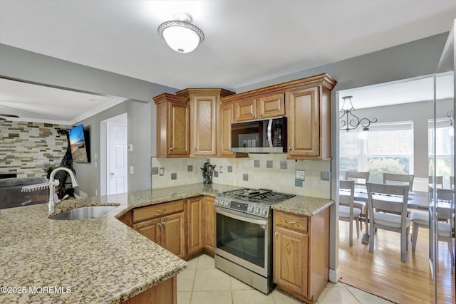 8 Shadow Ridge Ct, Howell, NJ 07731 - kitchen with stainless steel appliances, light stone counters, decorative backsplash, open floor plan, and brown cabinetry