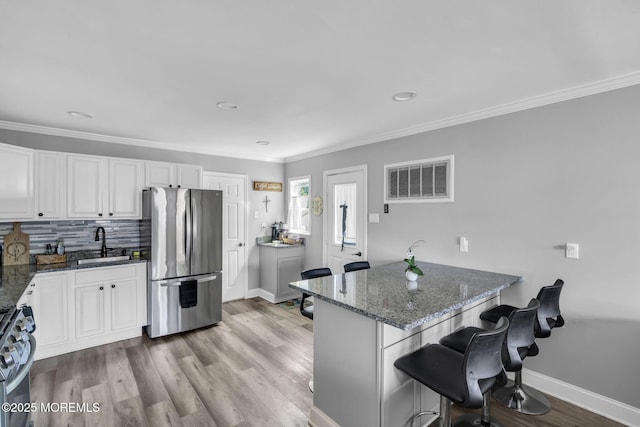 37 Kennedy Way, Keansburg, NJ 07734 - kitchen featuring freestanding refrigerator, range, a kitchen bar, dark stone counters, and crown molding
