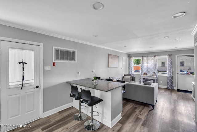 37 Kennedy Way, Keansburg, NJ 07734 - kitchen with ornamental molding, a peninsula, dark stone countertops, dark wood-style flooring, and a breakfast bar
