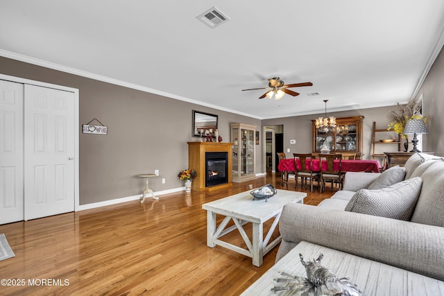 3 Redlands Ct, Toms River, NJ 08757 - living area with a glass covered fireplace, light wood finished floors, ceiling fan, ornamental molding, and a chandelier