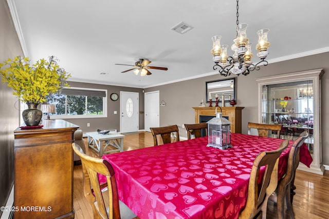 3 Redlands Ct, Toms River, NJ 08757 - dining room with wood finished floors, a ceiling fan, crown molding, a chandelier, and a fireplace